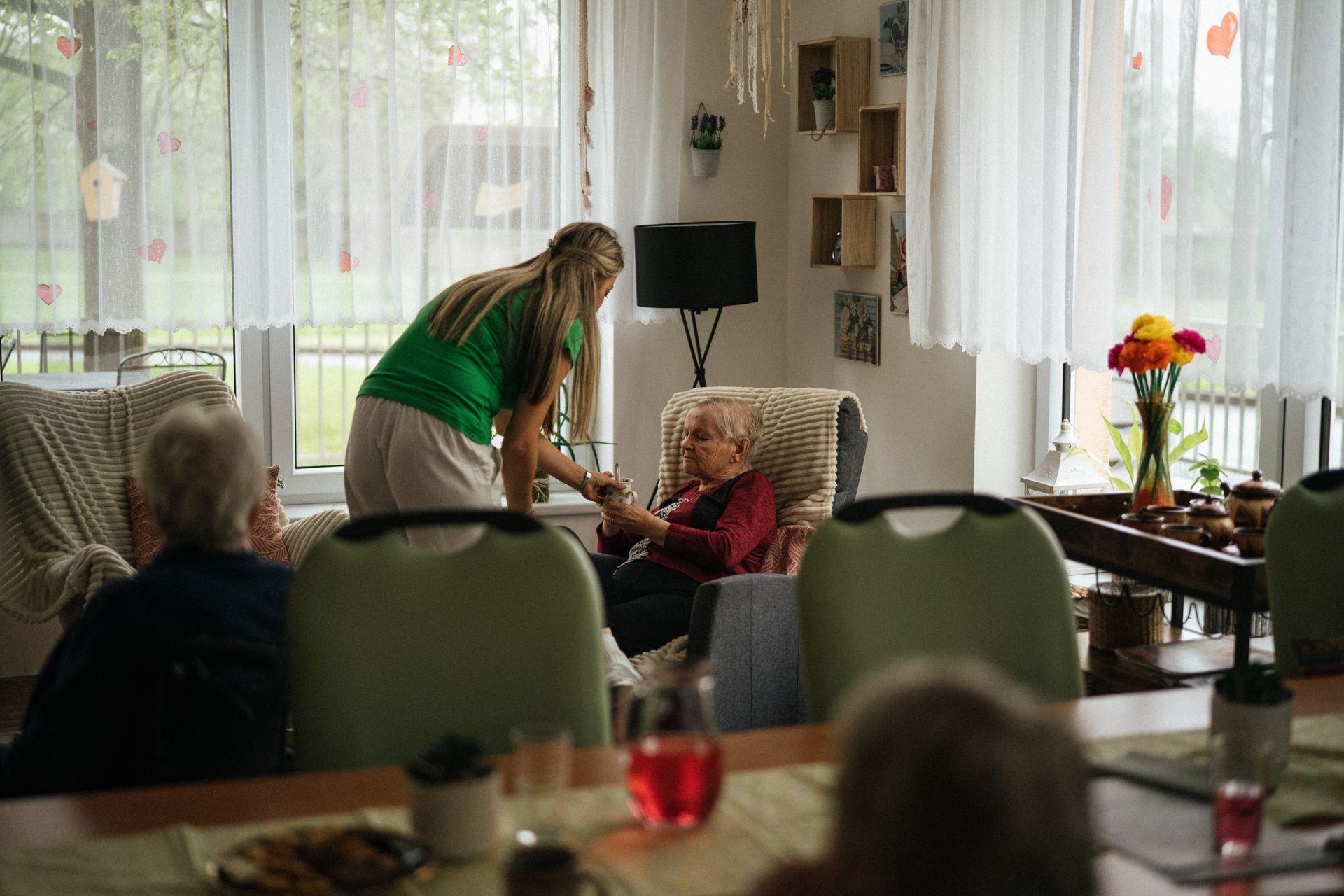 A support worker helping a resident with a cup of tea